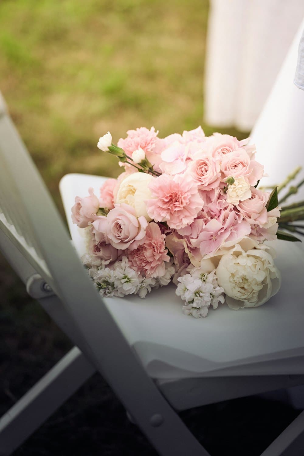 Pink and ivory bouquet on a white chair